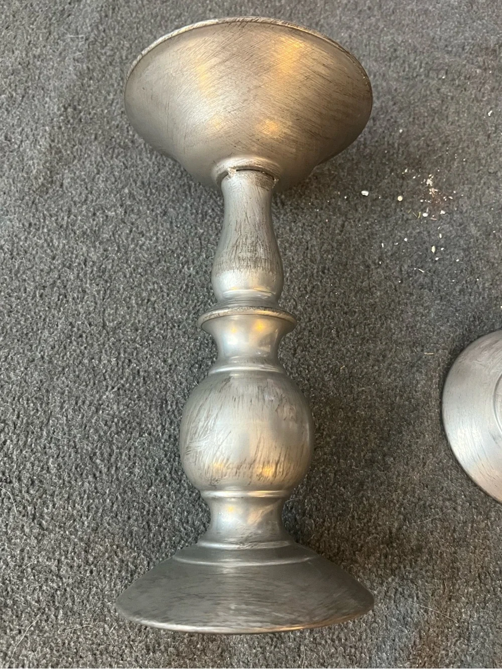set of three silver-tone metal candlestick holders features a graduated design